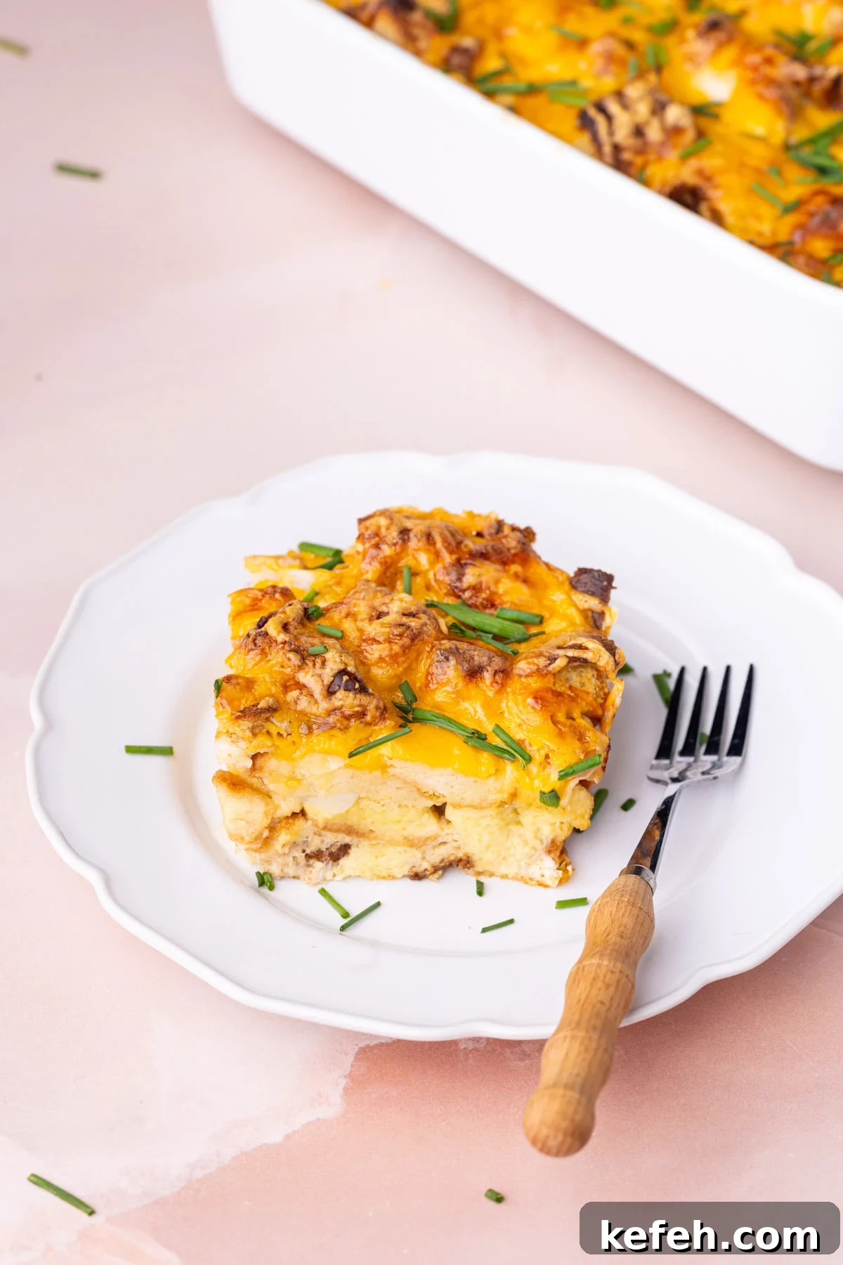 Savory Chive French Toast Casserole Recipe for Brunch 2 Generous portion of savory French toast casserole on a white plate peppered with chives.