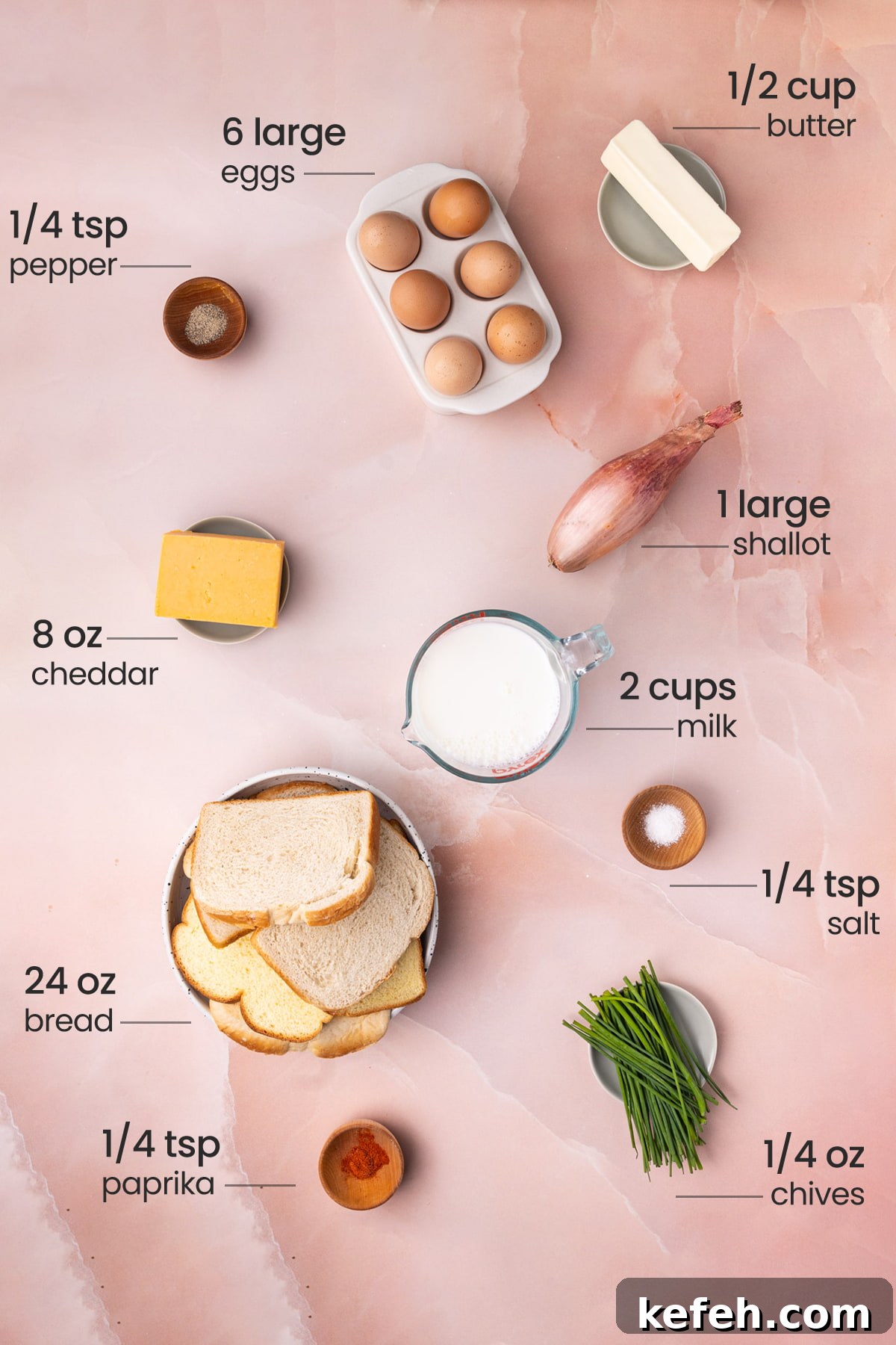 Savory Chive French Toast Casserole Recipe for Brunch 3 Overhead view of all the ingredients needed for savory French toast casserole - eggs, butter, pepper, shallot, cheddar, milk, salt, bread, paprika, and chives.