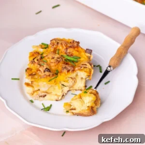 Savory Chive French Toast Casserole Recipe for Brunch 10 Thick slice of savory breakfast casserole on a white plate with a forkful off to the side.