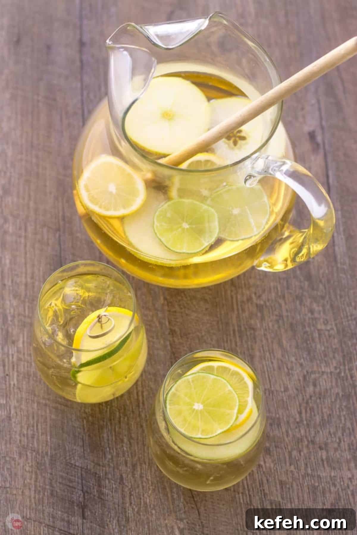 Refreshing Summer Sangria Recipe with Fresh Fruit 2 glasses of apple sangria next to a pitcher