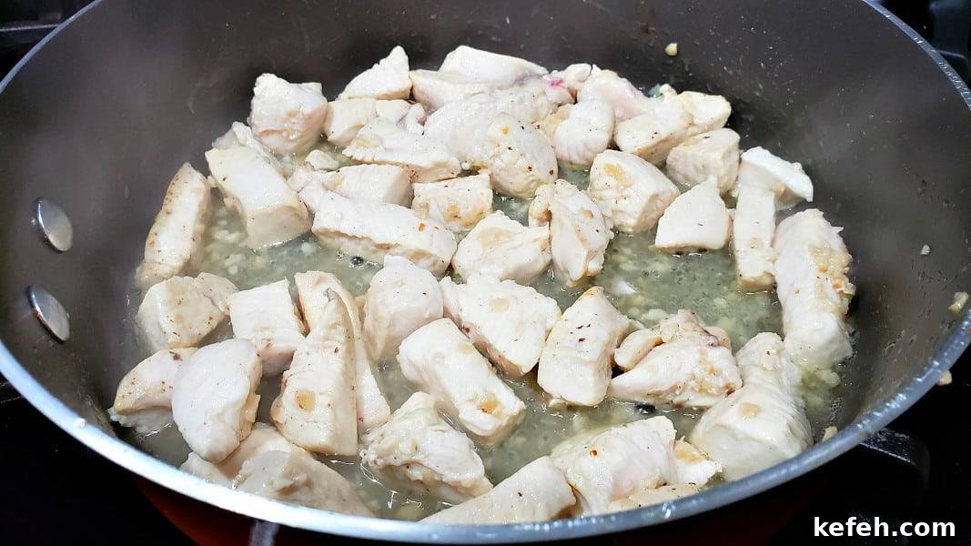 Creamy Bacon and Chicken Carbonara Recipe 6 diced chicken and garlic cooking in a large pan.