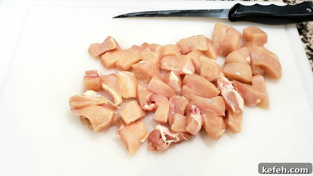 Creamy Bacon and Chicken Carbonara Recipe 5 bonless chicken diced on a cutting board.