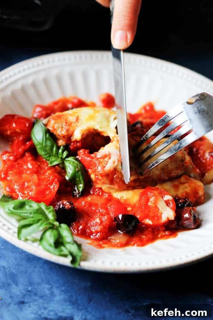 Veal Rollatini with Peppers, Cheese & Basil in Tomato-Olive Sauce 14 Veal Rollatini on a plate with fork and knife