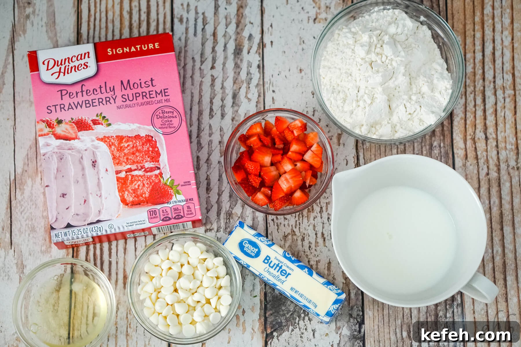 The ingredients needed to make strawberry cake mix scones: strawberry cake mix, chopped strawberries, flour, egg white, white chocolate chips, butter, and milk. 