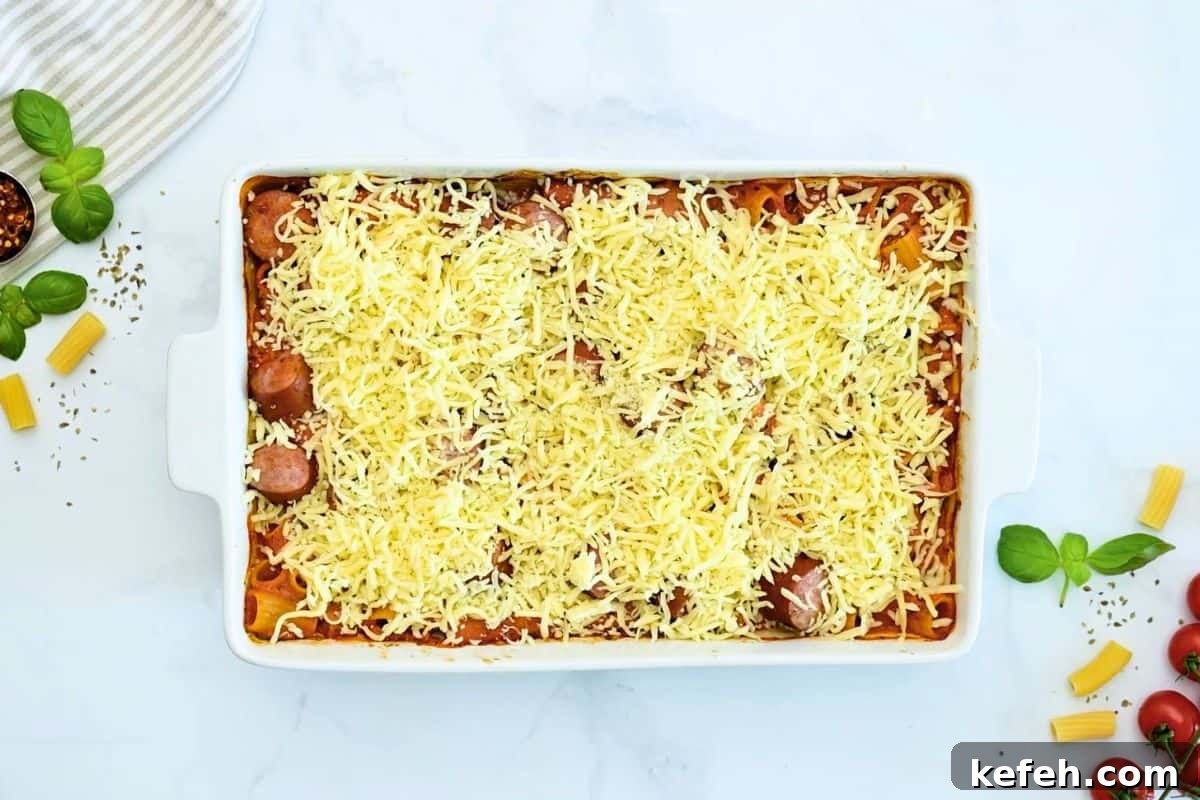 Cheesy Baked Rigatoni Baked rigatoni after baking until tender topped with cheese in large casserole dish.