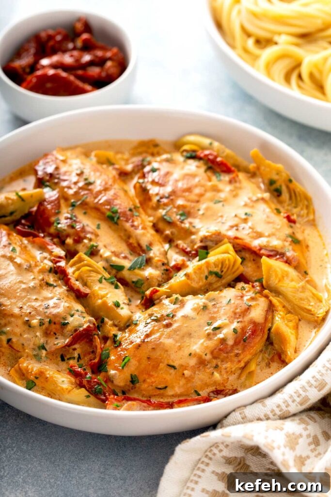Creamy Sun-Dried Tomato Chicken Skillet Recipe 2 Chicken breast in a creamy sauce made with sun dried tomatoes and artichokes on a white bowl