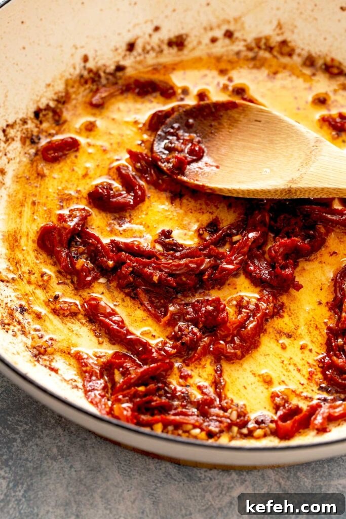 Creamy Sun-Dried Tomato Chicken Skillet Recipe 6 Minced garlic and sun dried tomato strips getting sautéed in a skillet.