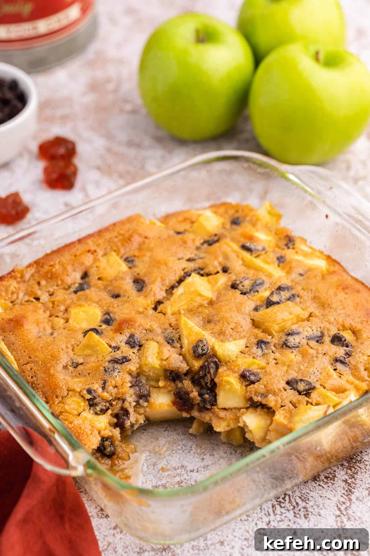 A pan of maple apple pudding with a piece removed.