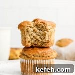 super fluffy gluten free banana muffins stacked with a bite taken out of the top muffin