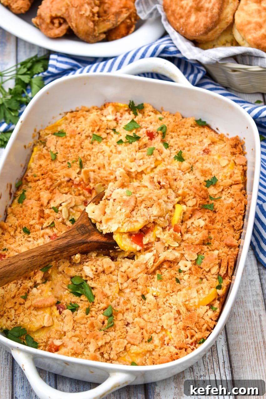 Classic Southern Squash Casserole Recipe for Comforting Dinners 4 a wooden spoon scooping southern squash casserole out of a white baking dish