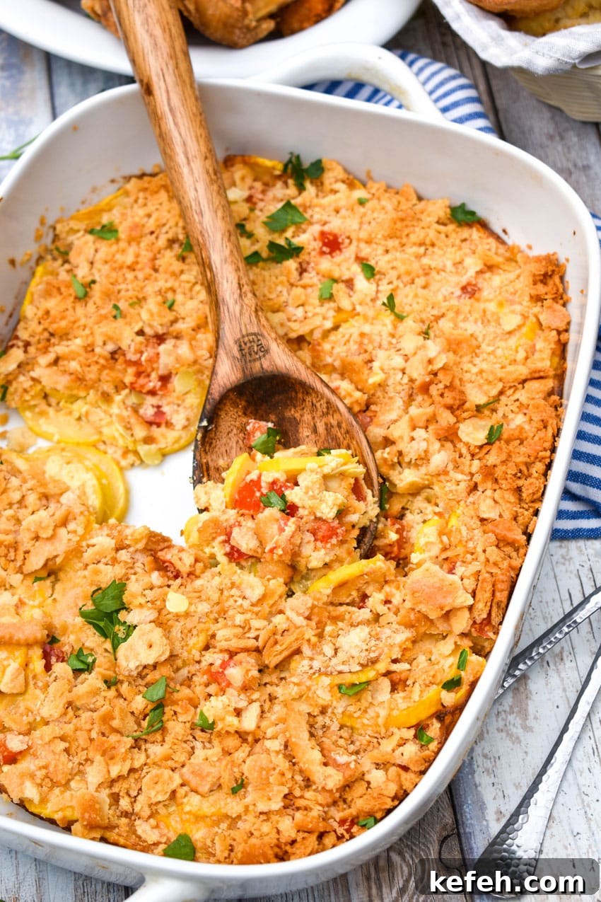 Classic Southern Squash Casserole Recipe for Comforting Dinners 5 a wooden spoon scooping southern squash casserole out of a white baking dish