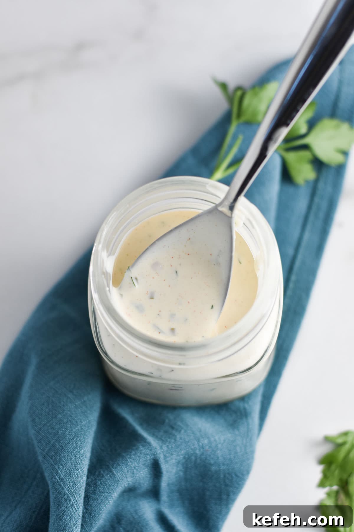Creamy Homemade Gluten-Free Ranch Dressing Recipe 6 A spoon dipping into ranch dressing.