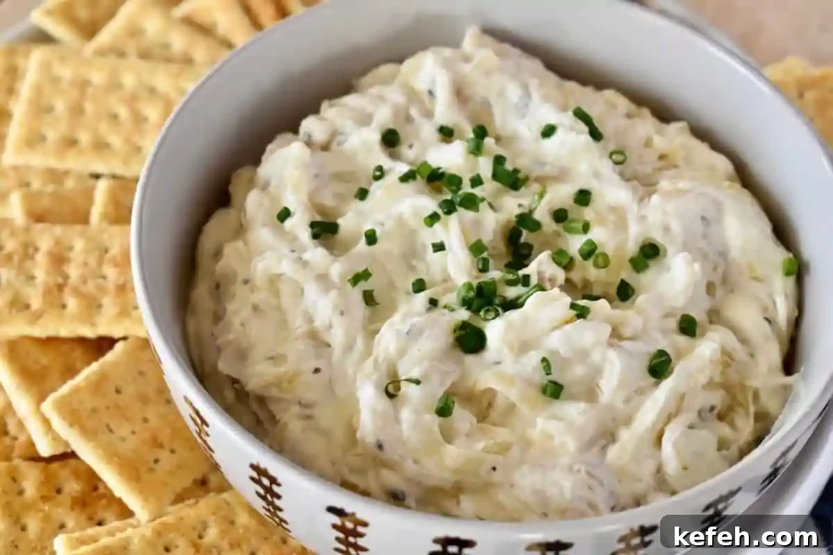 Caramelized Onion Dip Made with Greek Yogurt — Savory Party Dip 8 Dip in a bowl with crackers next to it.
