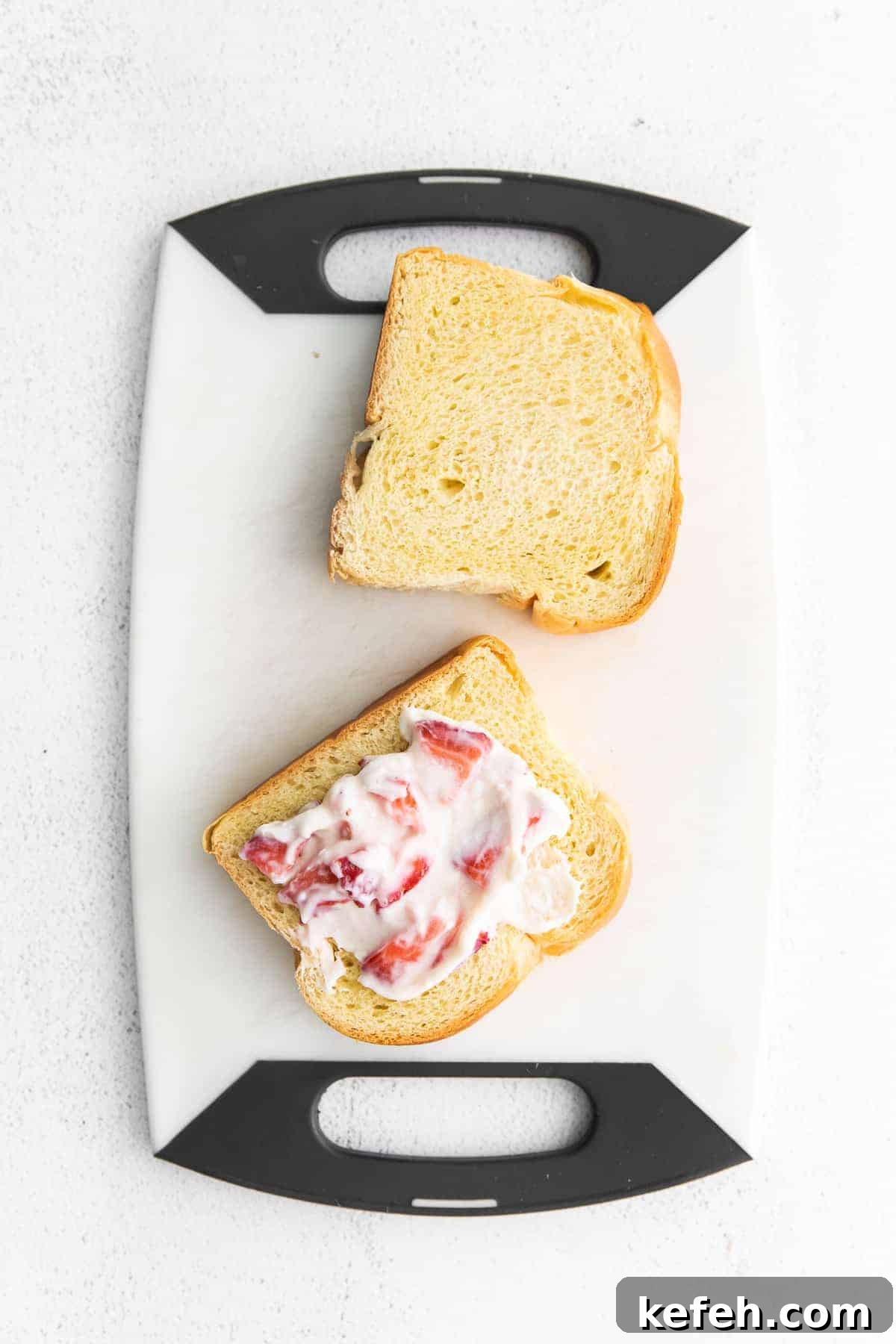 This deliciously decadent strawberries and cream stuffed French toast is perfect for your next brunch or special occasion. Two pieces of brioche bread with a strawberry cream cheese mixture ready to be made into stuffed french toast.