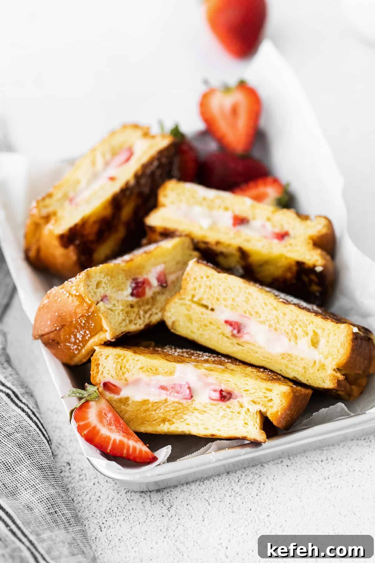 This deliciously decadent strawberries and cream stuffed French toast is perfect for your next brunch or special occasion. Strawberries and cream french toast in a serving tray.