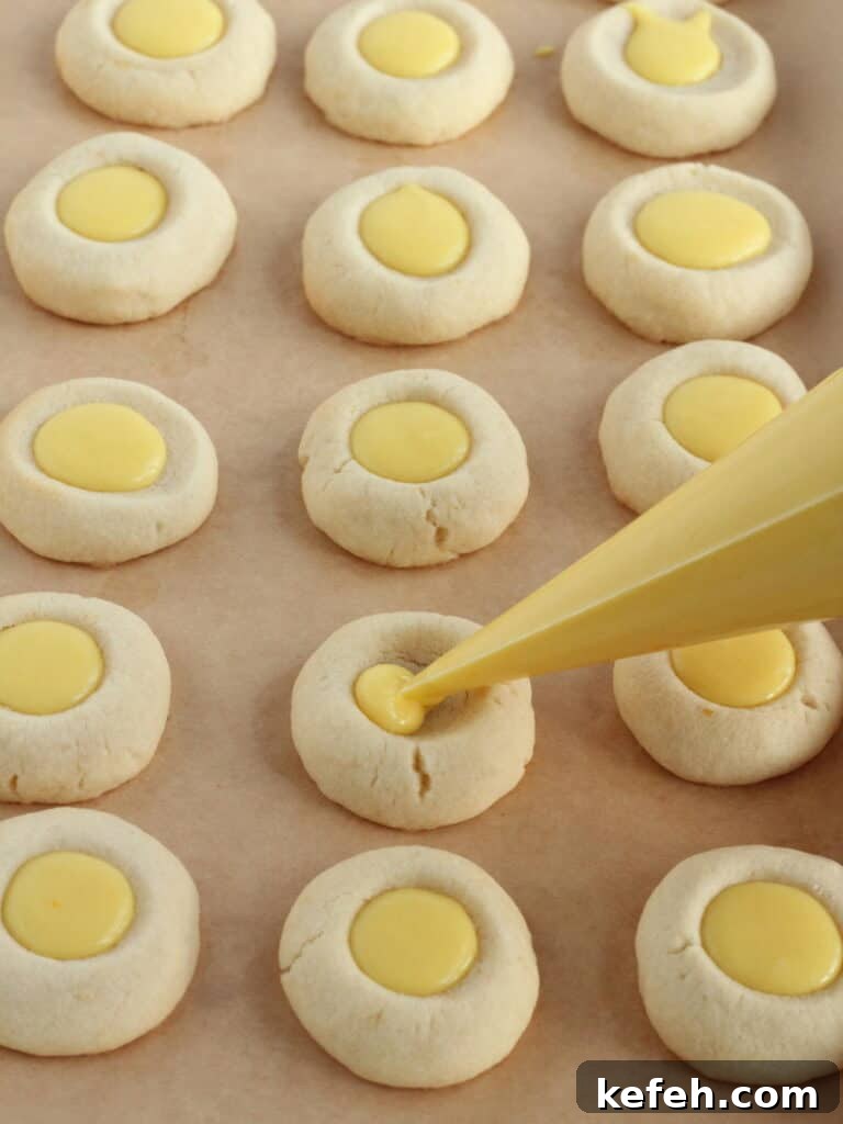 Filling lemon cookies with lemon curd.