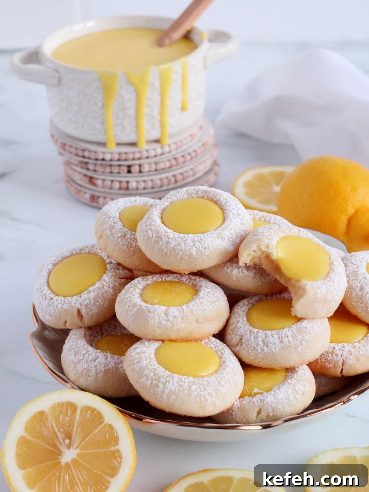 Tower of lemon thumbprint cookies filled with lemon curd.
