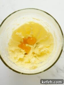 Adding eggs to lemon cookie batter.