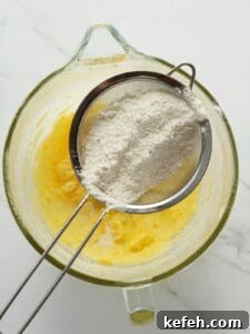 Sifting manually flour to lemon cookie dough.