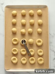 Making little wells in cookie dough.