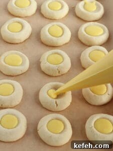 Filling lemon cookies with lemon curd.