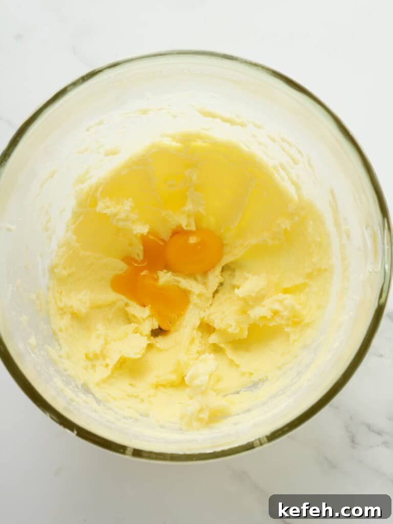 Adding eggs to lemon cookie batter.