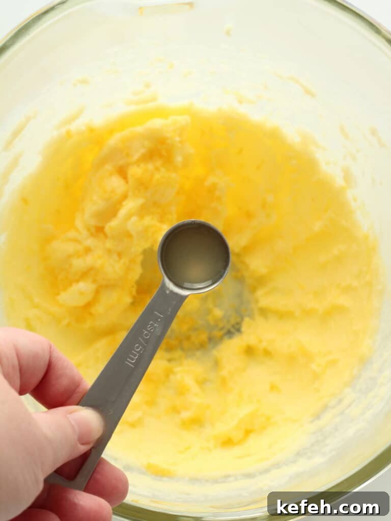 Adding lemon juice to lemon cookie dough.