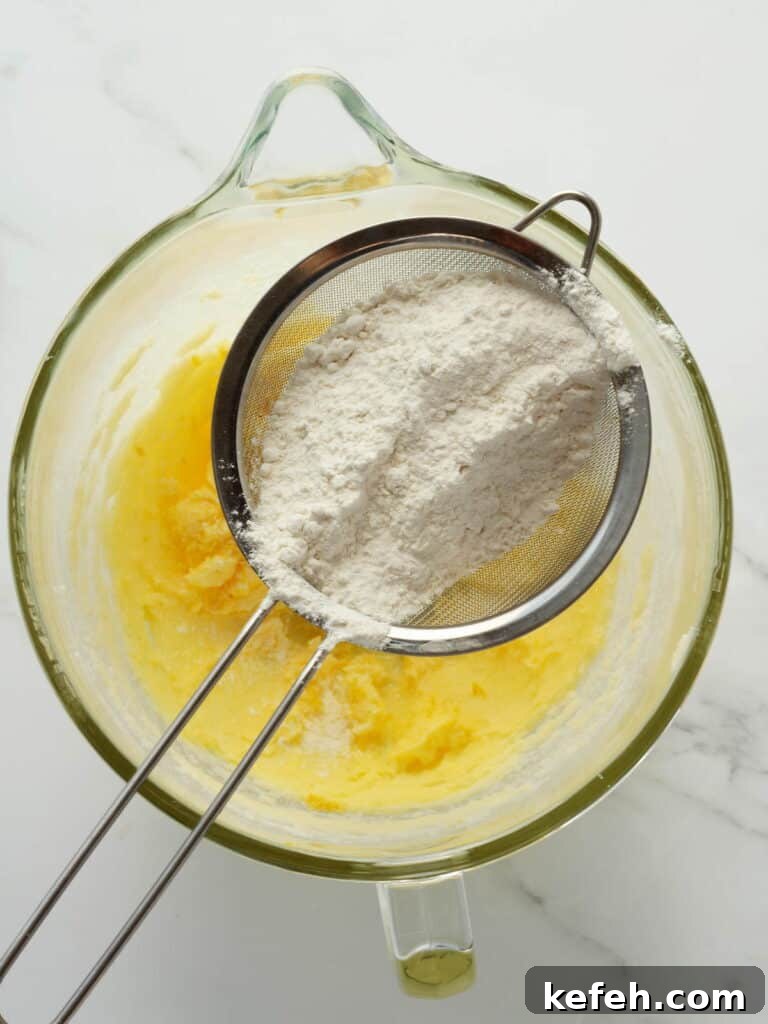 Sifting manually flour to lemon cookie dough.