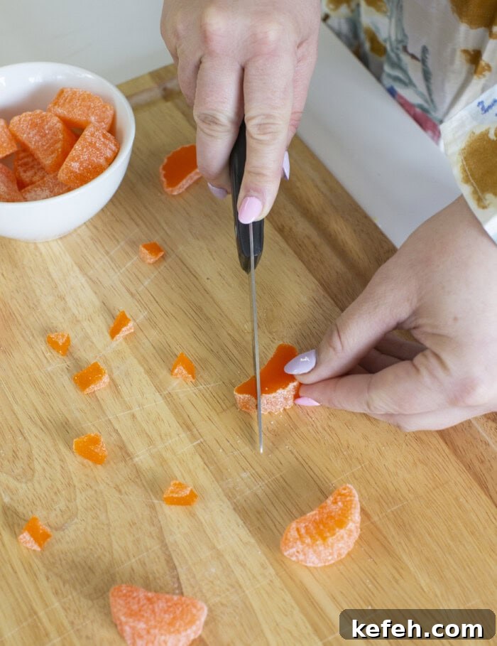 Process shot of cutting orange candy slices for the Easter chick cupcakes.