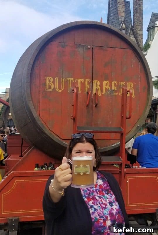 Top Tips for Visiting The Wizarding World of Harry Potter 3 Tammilee holding a butter beer in front o the Butter Beer stand
