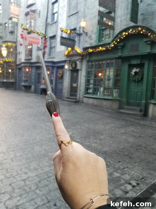 Top Tips for Visiting The Wizarding World of Harry Potter 6 Hand wearing Harry Potter ring holding a wand in Diagon Alley