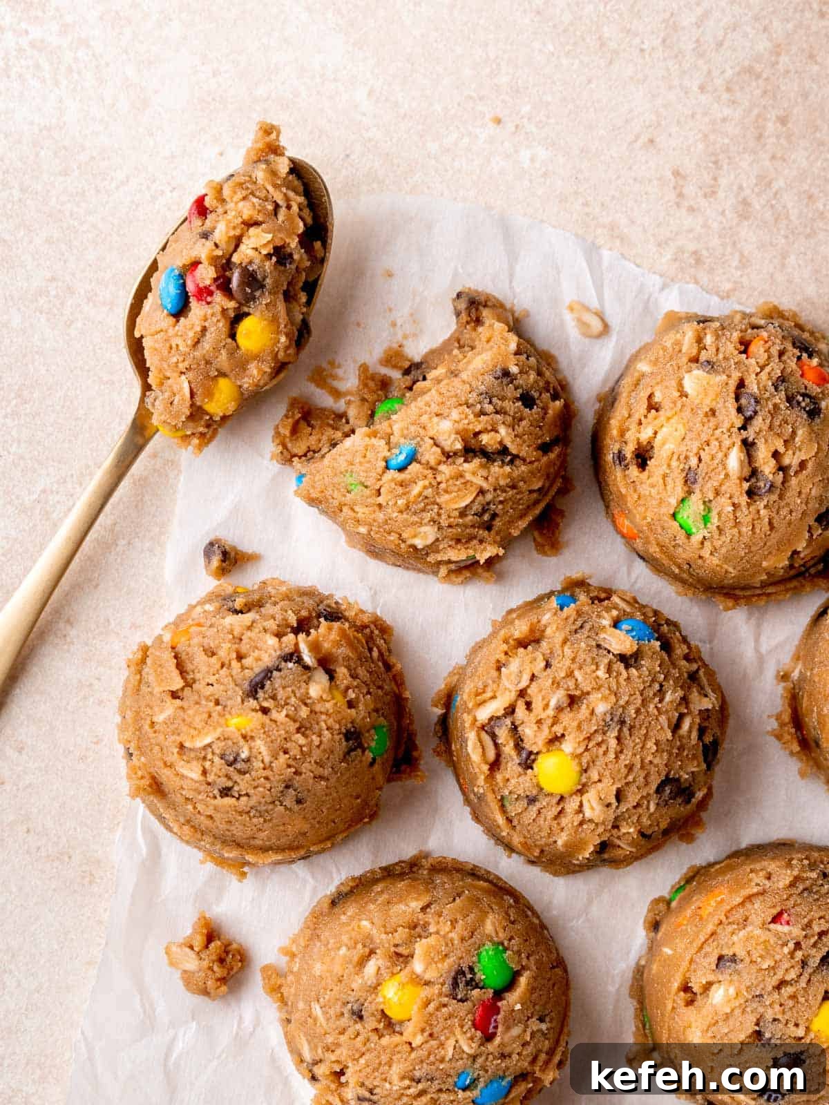 Edible Monster Cookie Dough Recipe for Safe No-Bake Treats 2 Scoops of edible monster cookie dough on parchment paper.