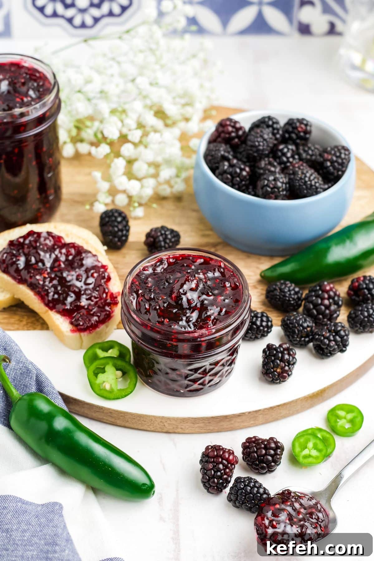 Spicy Blackberry Jalapeño Jam Recipe for Preserving and Gifts 8 Blackberry jalapeno jam in a jar with some spread on a toast to the side and fresh berries around on the table.