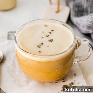 A cup of London fog lavender latte with a spoon on a napkin.