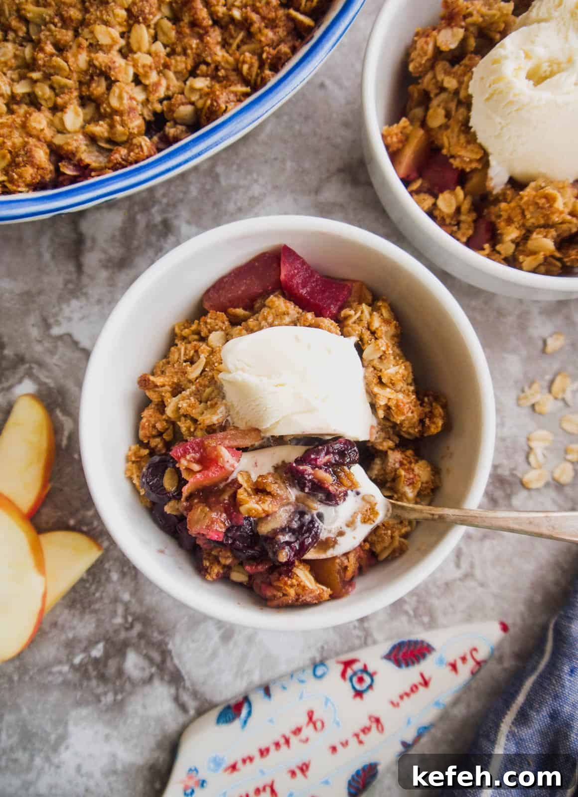 Cherry apple crisp in two bowls with ice-cream on top.