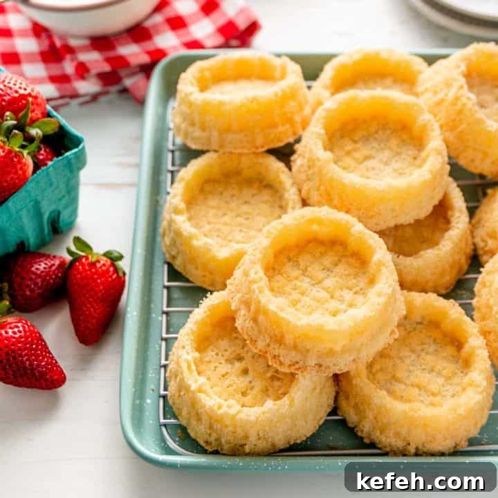 A pile of dessert shells on a green speckled baking pan.