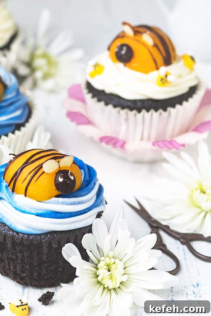 Bumblebee Chocolate Cupcakes with Cream Cheese Swirl Frosting 3 Two bumblebee cupcakes with flowers sitting on a table.