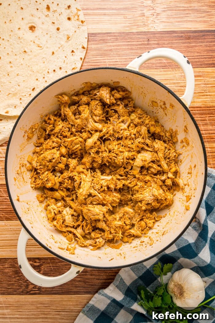 Shredded chicken with seasoning in a skillet