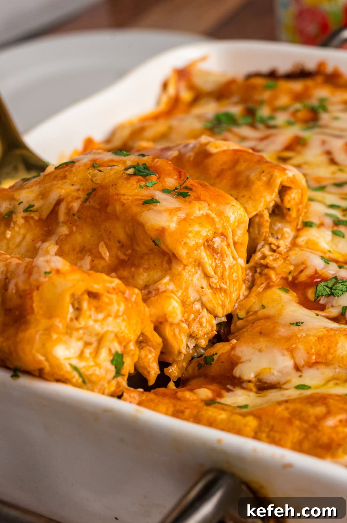A spatula serving red chicken enchiladas