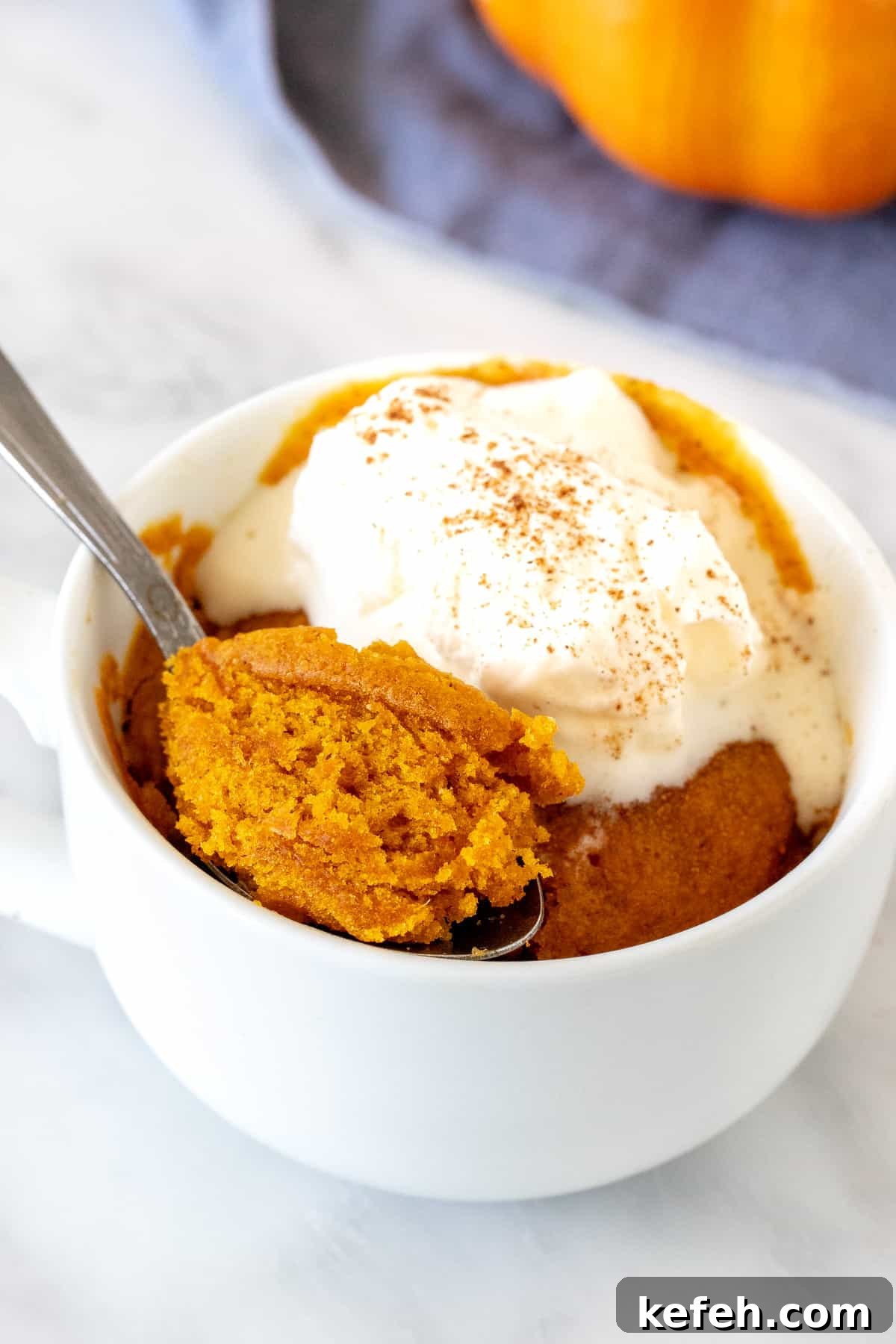 Pumpkin mug cake topped with whipped cream
