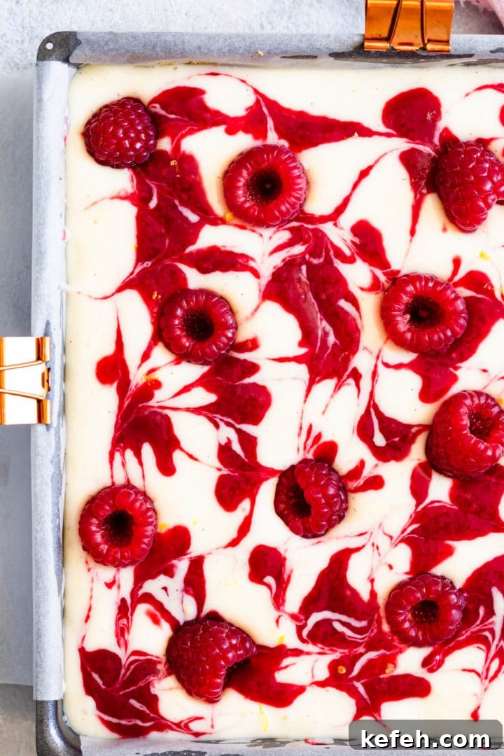 top down super close up of a raspberry lemon cheesecake batter with swirls
