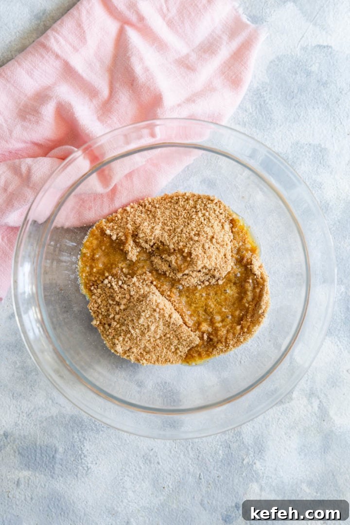 overhead shot of a bowl with biscuit crumbs and melted butter