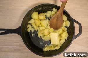 Adding the butter to the potatoes