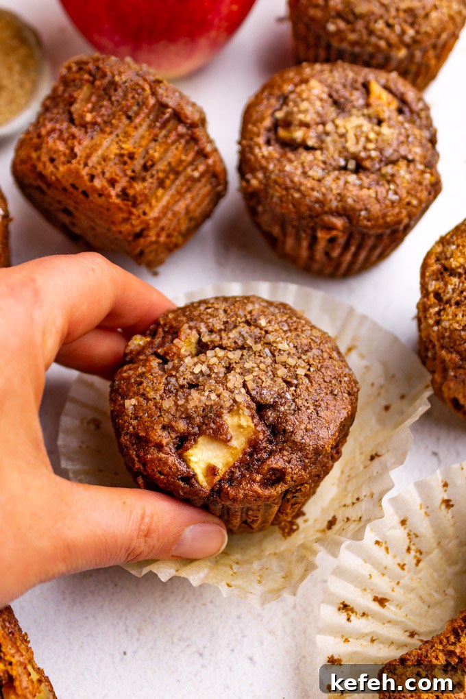 Moist Apple Butter Muffins with Warm Cinnamon Flavor 8 closeup of apple butter muffins with a hand grabbing a muffin.