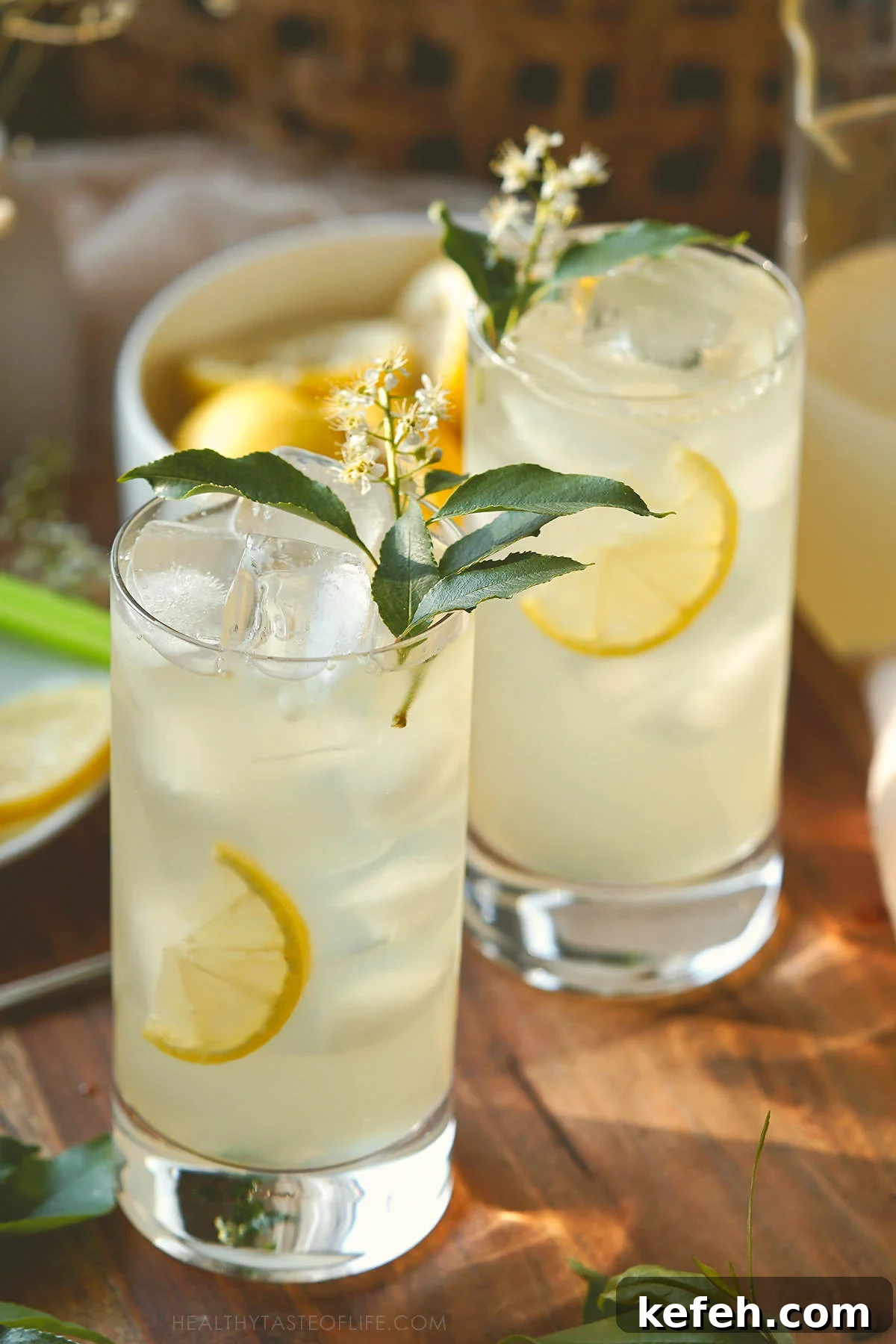 Photo of two high glasses filled with homemade elderflower lemonade served over ice.