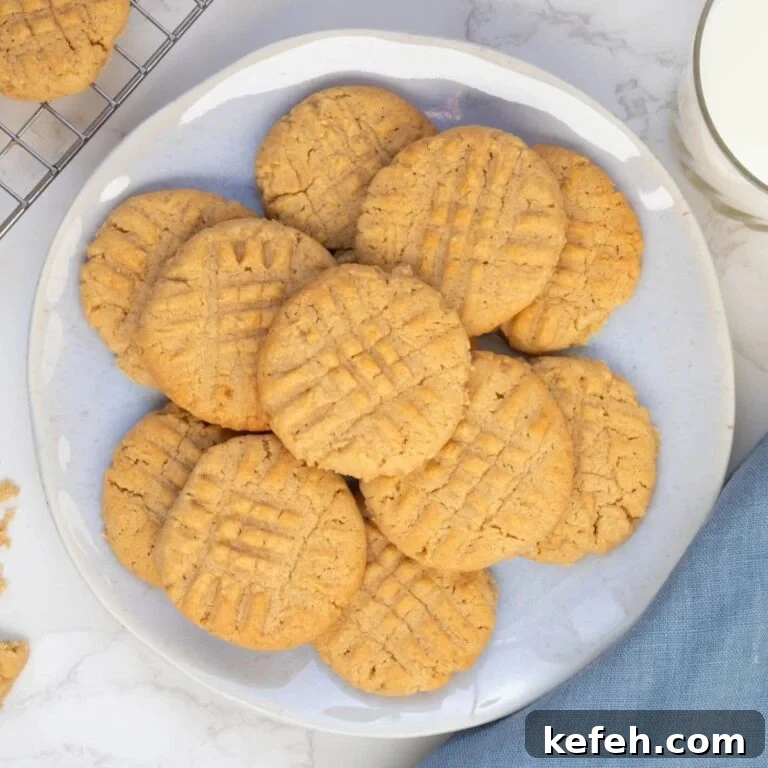 Golden sourdough peanut butter cookies with classic fork marks arranged on a serving plate.