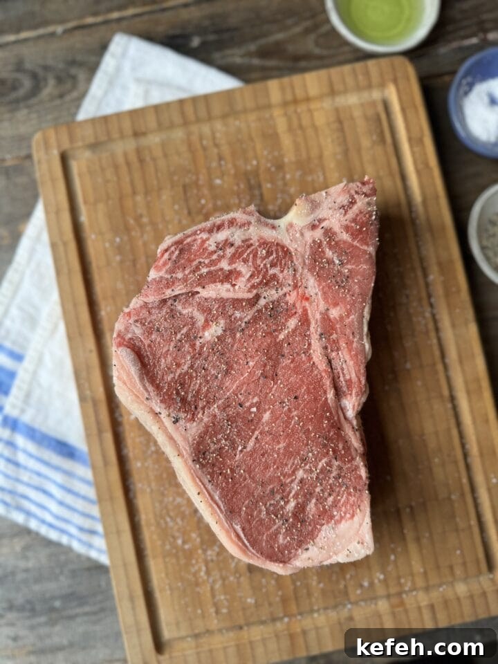 T-Bone Steak Recipe with Garlic Butter and Herbs 3 Juicy raw T-bone steak seasoned with salt and pepper on a wooden cutting board.