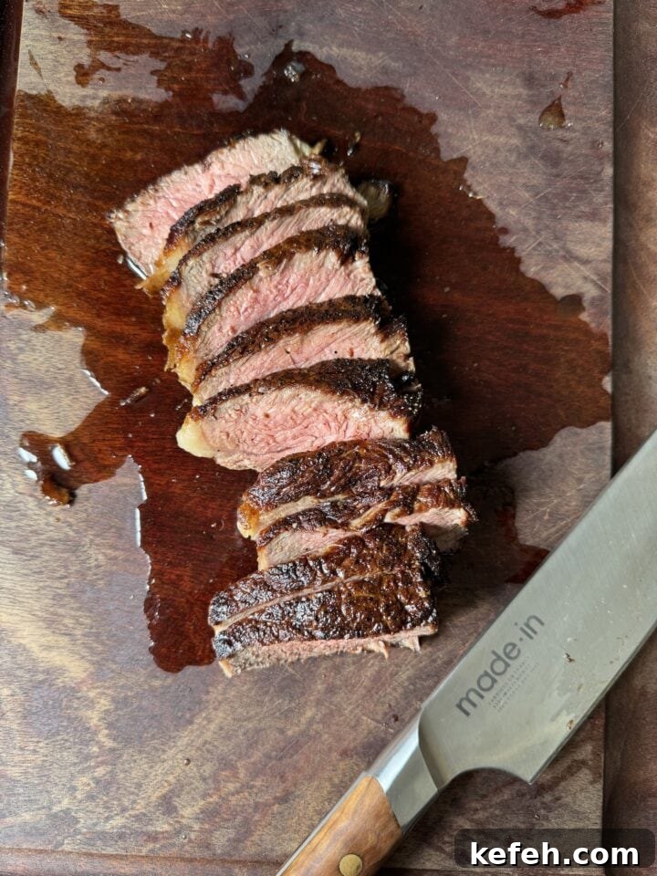 T-Bone Steak Recipe with Garlic Butter and Herbs 8 Juicy perfectly cooked steak sliced on wooden cutting board with drippings, high-quality home cooking image.