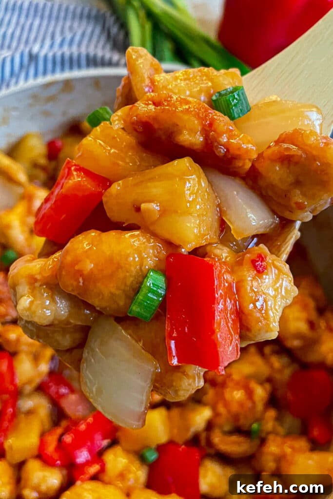 Copycat Panda Express Sweet Fire Chicken Recipe You Can Make at Home 3 close up shot of copycat panda express sweet fire chicken on a wooden serving spoon