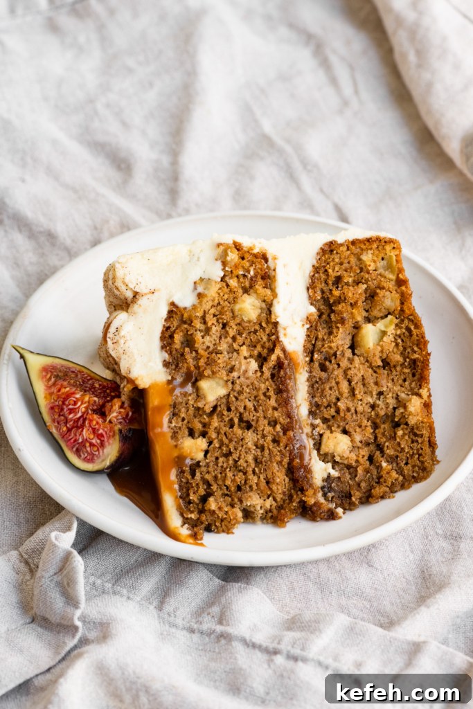 Warm Caramel Apple Spice Cake Recipe 3 Slice of frosted apple cake on a plate with caramel sauce on top and sliced fig.